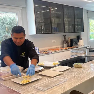 Cocinero y camarero de Cardamomo emplatando los aperitivos en la cocina de la casa