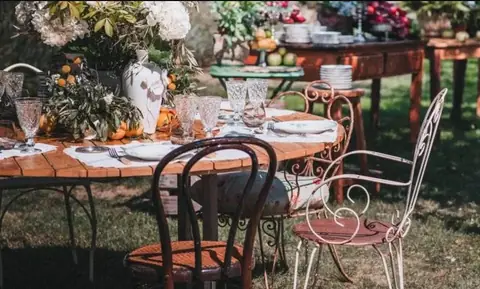 Sillas de hierro bien decoradas en una mesa de boda llena de flores