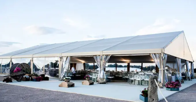 Carpa de color blanco con mesas de boda en su interior