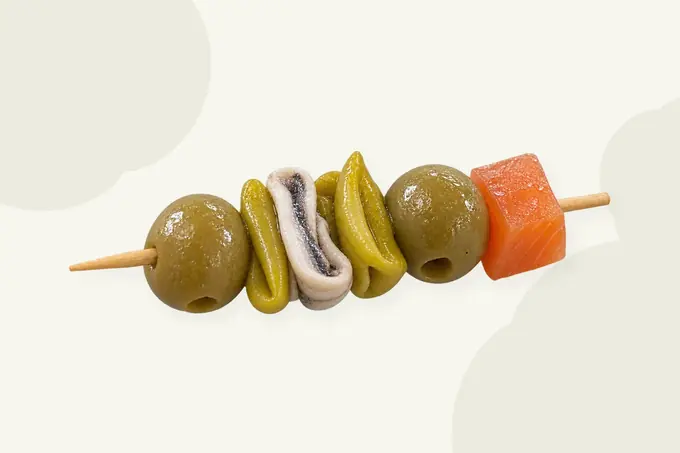 Una gilda montada con aceitunas, piparras, boquerón y salmón ahumado en un palillo