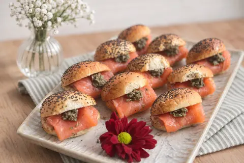 Bandeja de mini brioches de amapola rellenos de salmón ahumado y alcaparras