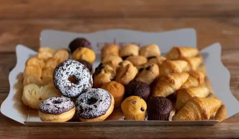 Bandeja de mini bollería variada con croissants, mini muffins, donuts y palmeritas para desayunos de empresa