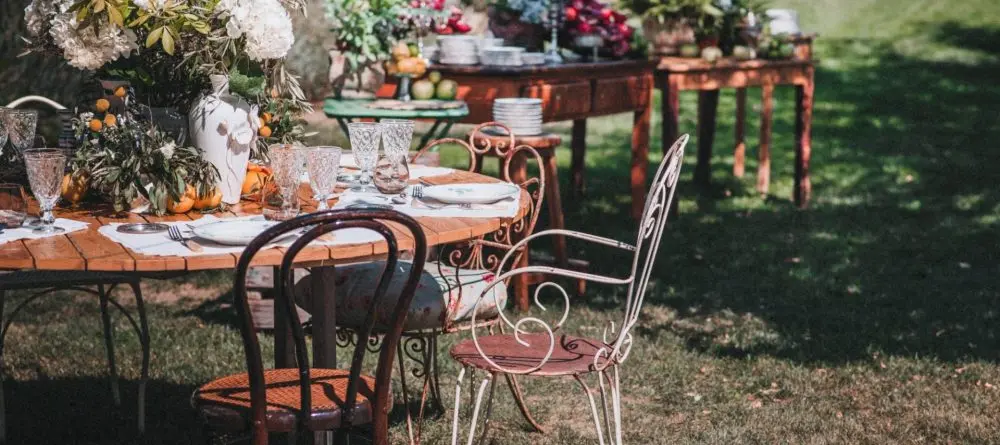 Jardín decorado para un evento con sillas de hierro y flores